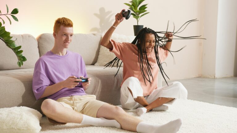 A young man and woman enjoying a fun video game session on a comfortable sofa.